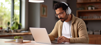 Behavioral healthcare provider sitting at a laptop wearing headphones
